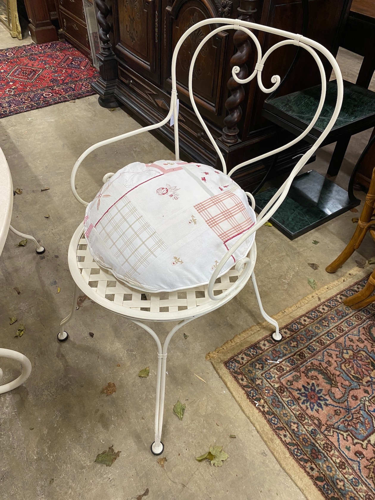 A circular reconstituted marble garden table, diameter 120cm, height 74cm and four painted wrought iron chairs